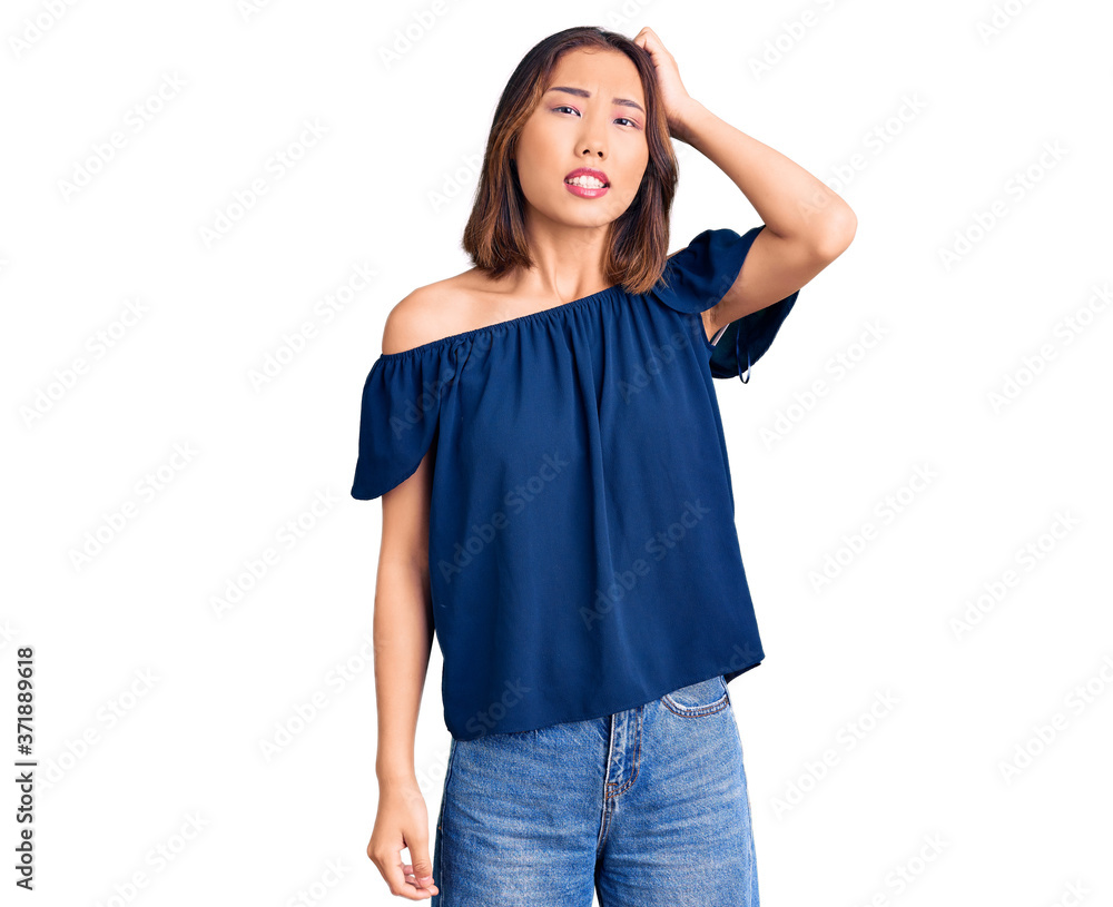 Young beautiful chinese girl wearing casual clothes confuse and wonder about question. uncertain with doubt, thinking with hand on head. pensive concept. Young beautiful chinese girl wearing casual clothes confuse and wonder about question. uncertain with doubt, thinking with hand on head. pensive concept.