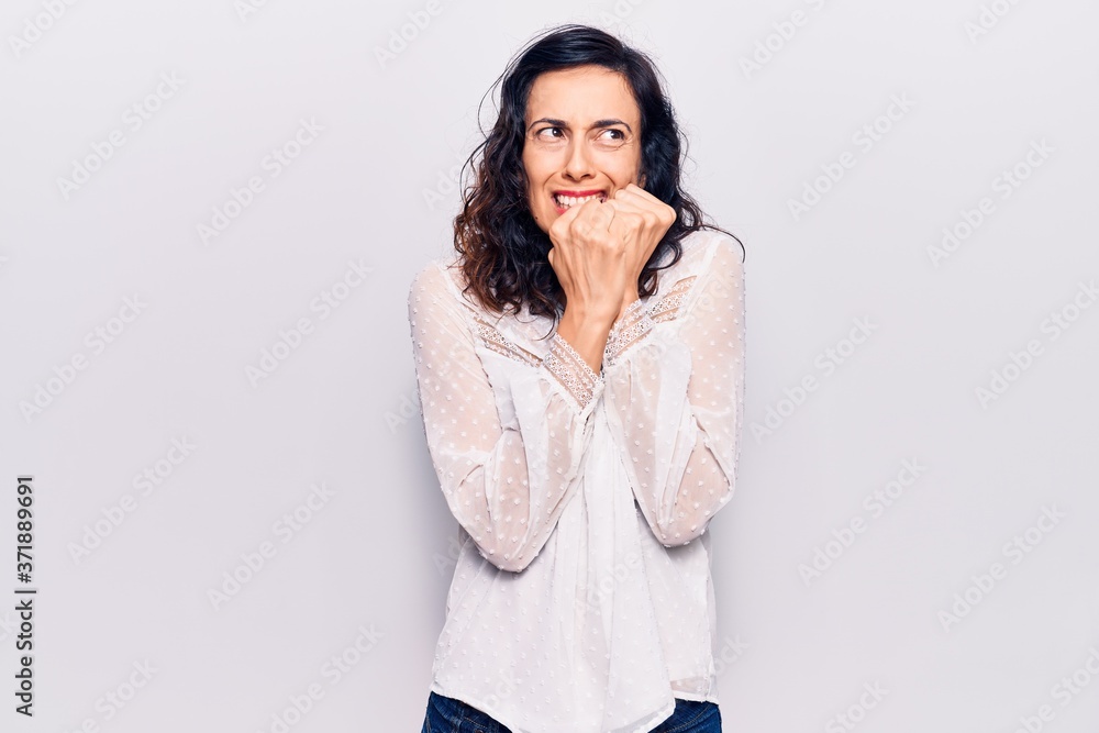 Young beautiful hispanic woman wearing casual clothes looking stressed and nervous with hands on mouth biting nails. anxiety problem. Young beautiful hispanic woman wearing casual clothes looking stressed and nervous with hands on mouth biting nails. anxiety problem.
