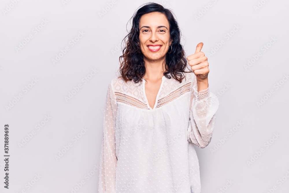 Young beautiful hispanic woman wearing casual clothes smiling happy and positive, thumb up doing excellent and approval sign Young beautiful hispanic woman wearing casual clothes smiling happy and positive, thumb up doing excellent and approval sign
