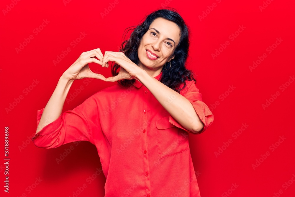 Young beautiful hispanic woman wearing casual clothes smiling in love showing heart symbol and shape with hands. romantic concept. Young beautiful hispanic woman wearing casual clothes smiling in love showing heart symbol and shape with hands. romantic concept.