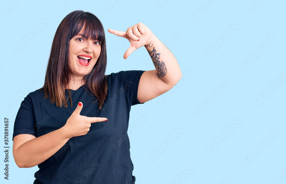 Young plus size woman wearing casual clothes smiling making frame with hands and fingers with happy face. creativity and photography concept. Young plus size woman wearing casual clothes smiling making frame with hands and fingers with happy face. creativity and photography concept.