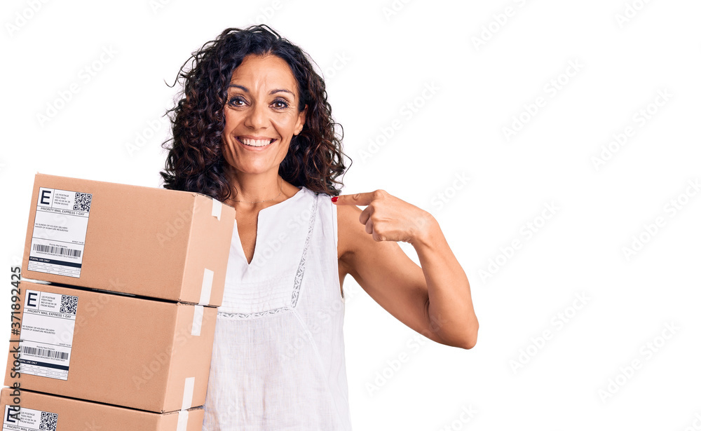 Middle age beautiful woman holding delivery package pointing finger to one self smiling happy and proud Middle age beautiful woman holding delivery package pointing finger to one self smiling happy and proud