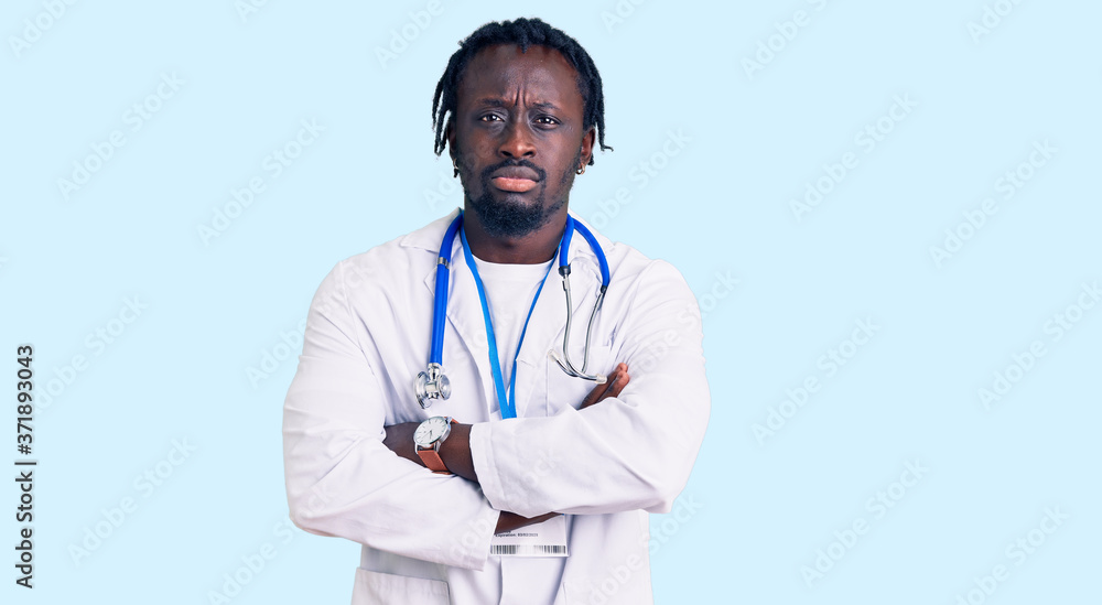 Young african american man with braids wearing doctor stethoscope and id pass skeptic and nervous, disapproving expression on face with crossed arms. negative person. Young african american man with braids wearing doctor stethoscope and id pass skeptic and nervous, disapproving expression on face with crossed arms. negative person.