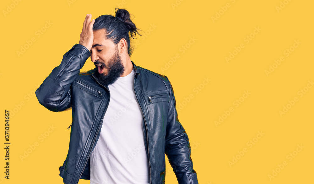 Young arab man wearing casual leather jacket surprised with hand on head for mistake, remember error. forgot, bad memory concept. Young arab man wearing casual leather jacket surprised with hand on head for mistake, remember error. forgot, bad memory concept.