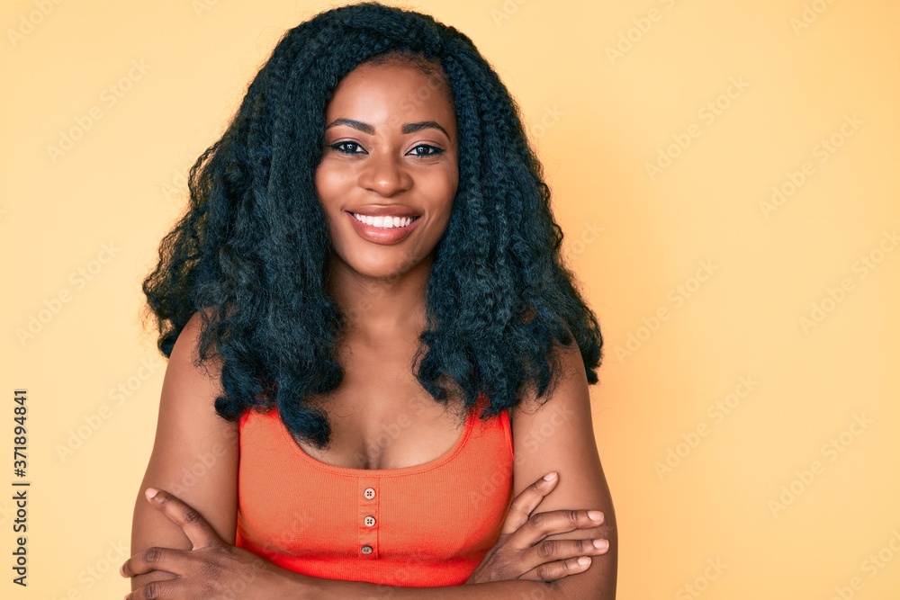 Beautiful african woman wearing casual clothes happy face smiling with crossed arms looking at the camera. positive person.