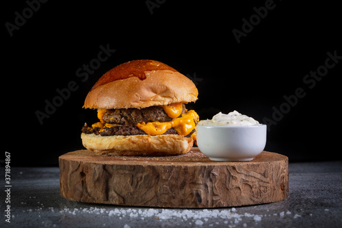 Two smash burger with cheddar cheese and garlic sauce . photo