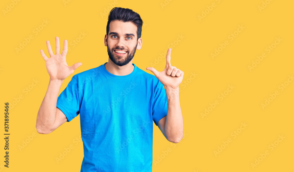 Young handsome man with beard wearing casual t-shirt showing and pointing up with fingers number seven while smiling confident and happy. Young handsome man with beard wearing casual t-shirt showing and pointing up with fingers number seven while smiling confident and happy.