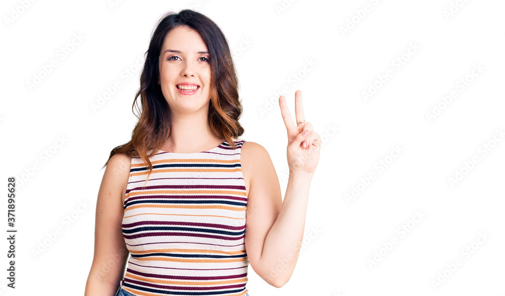 Beautiful young brunette woman wearing casual clothes smiling with happy face winking at the camera doing victory sign. number two. Beautiful young brunette woman wearing casual clothes smiling with happy face winking at the camera doing victory sign. number two.
