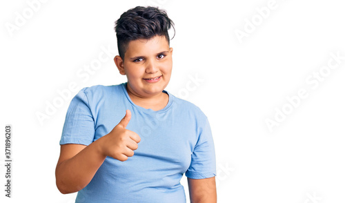 Little boy kid wearing sports workout clothes doing happy thumbs up gesture with hand. approving expression looking at the camera showing success. © Krakenimages.com