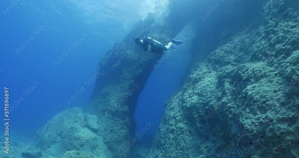 Scuba Path scuba divers exploring and swimming around an arch underwater cave and ...