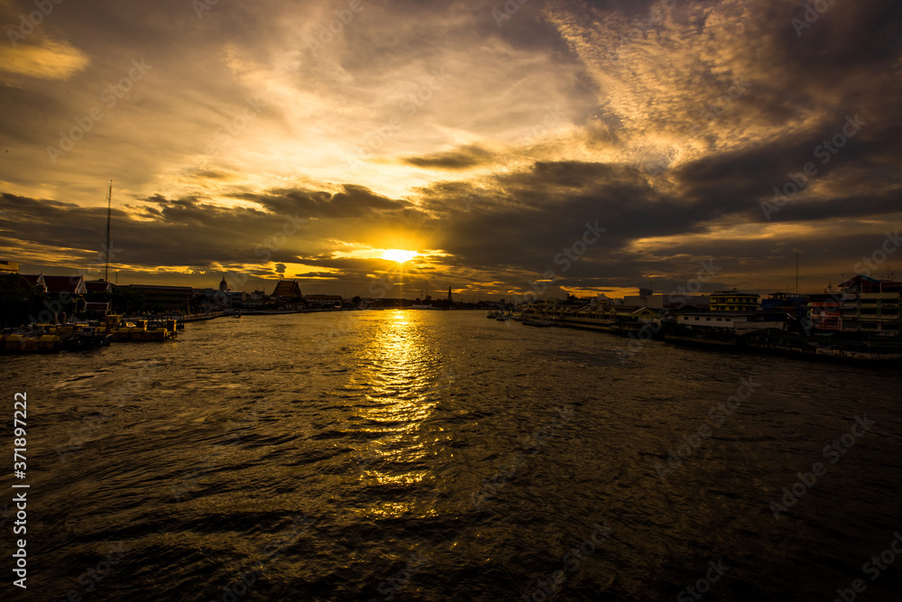 The blurred abstract background of the evening sun shining on the river is naturally golden yellow, the beauty of the clouds and the weather conditions of the day.