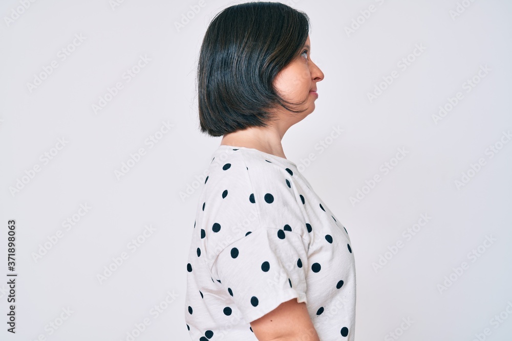 Brunette woman with down syndrome wearing casual clothes looking to side, relax profile pose with natural face with confident smile. Brunette woman with down syndrome wearing casual clothes looking to side, relax profile pose with natural face with confident smile.