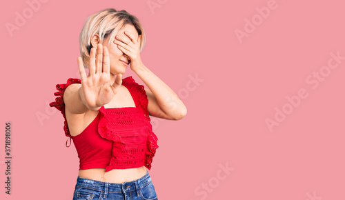 Young beautiful blonde woman wearing casual clothes covering eyes with hands and doing stop gesture with sad and fear expression. embarrassed and negative concept. © Krakenimages.com