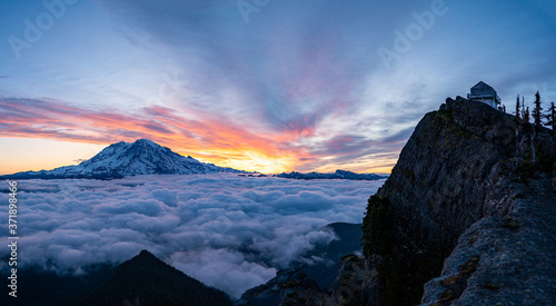 Panoramic view of Mount Rainier above the clouds during the sunrise with dramatic color in the sky © suchavadee27