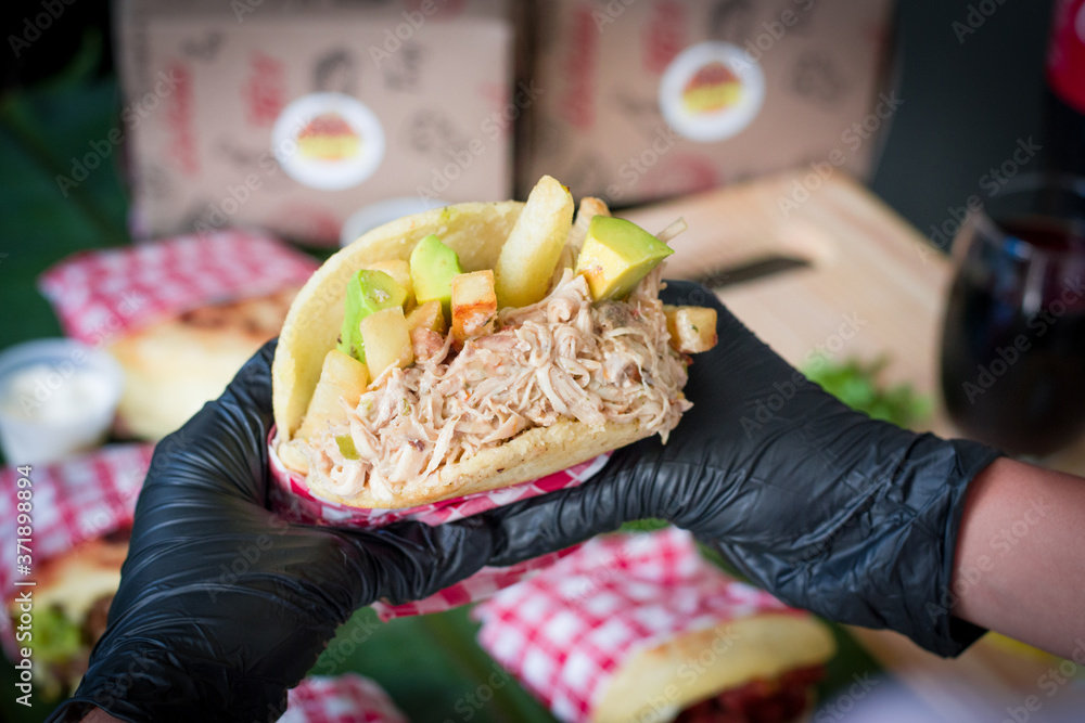 person with arepa in hands, person eating arepas, person showing arepa