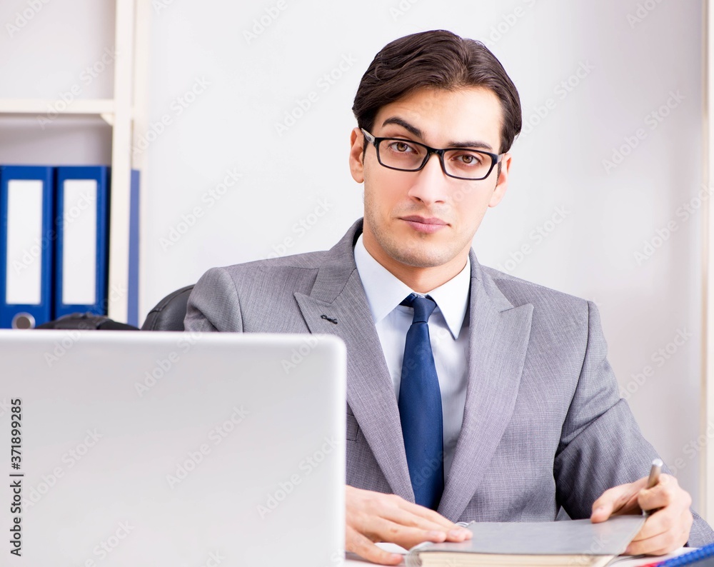 Young handsome businessman employee working in office at desk Young handsome businessman employee working in office at desk