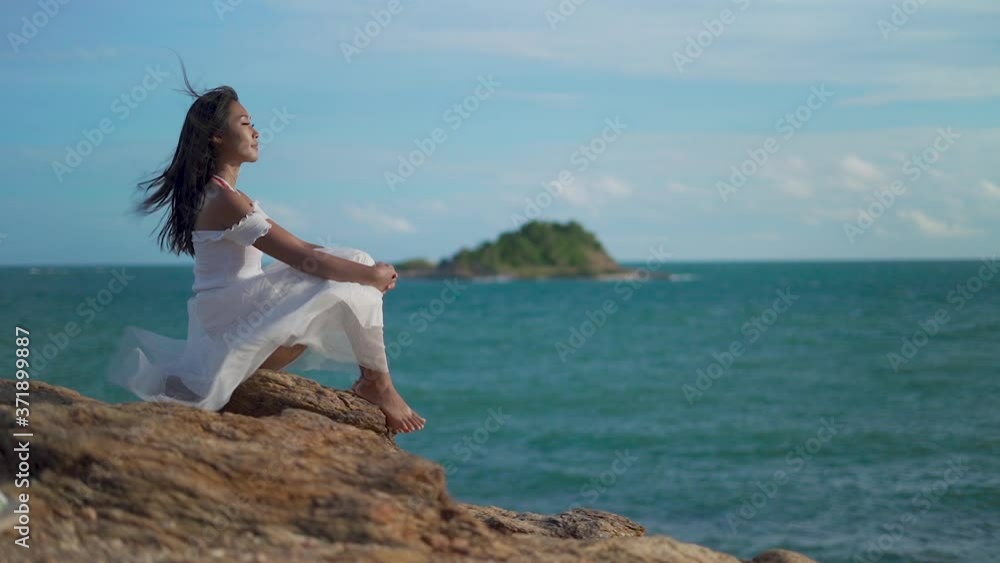 Slow motion clips,A beautiful woman sitting on the rocks watching the sea view, Koh Samed in Thailand. Slow motion clips,A beautiful woman sitting on the rocks watching the sea view, Koh Samed in Thailand.