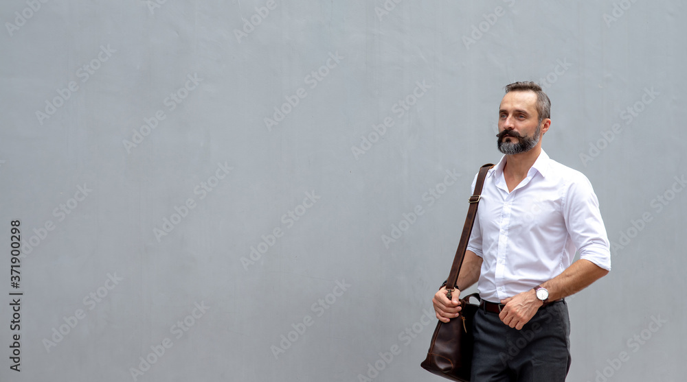 Fototapeta premium Portrait of Confidence Caucasian business man office worker carrying leather briefcase walking in city street to office district for working. Handsome beard guy entrepreneur enjoy outdoor city life.