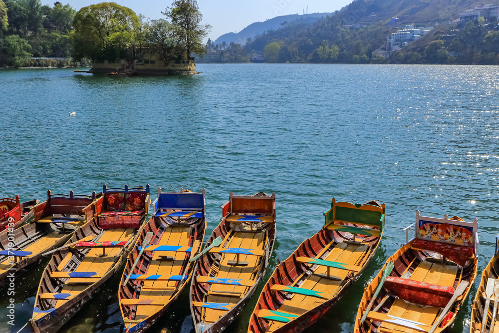 Boats floating on water in a lake in hill station Bhimtal in Nainital district of India a famous tourist destination
