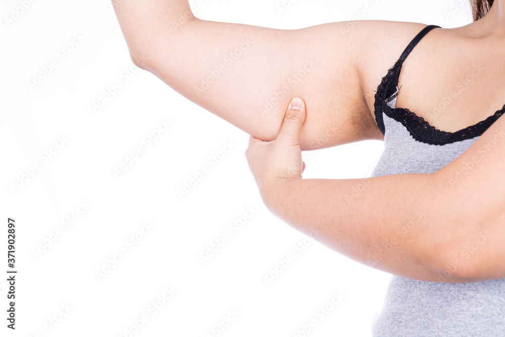 Woman holding excessive fat arm isolated on over white background. Woman pinching arm fat flabby skin. Weight loss, slim body, healthy lifestyle concept.