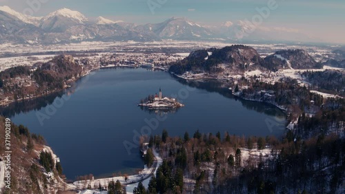 Winter drone shot of a lake Bled with a famous island and mountains in the background. photo