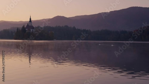 Beautiful morning foggy scene of a small island Bled and charming little church drone video photo