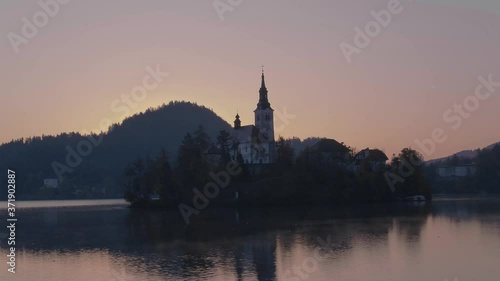 Reflective drone video of a small island Bled and church photo