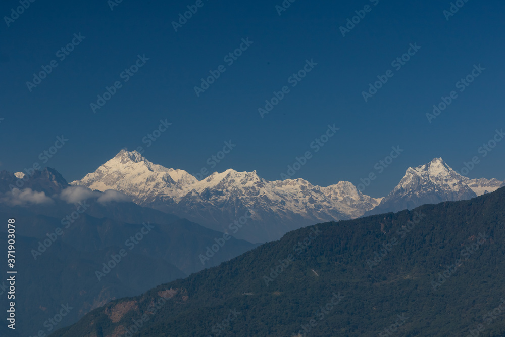 A panoramic view of Mt Kanchenjunga with first rays of sunlight falling on it 