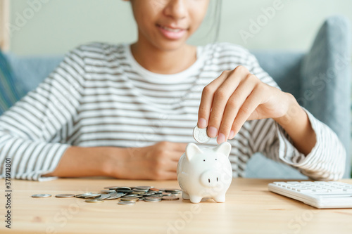 Papier peint Success Asian girl is put coins in piggy bank For future scholarships