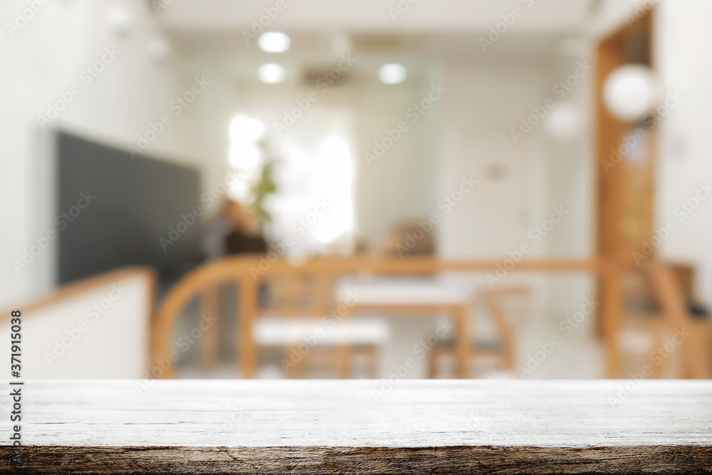 coffee shop blurred background with empty wooden desk montage. coffee shop blurred background with empty wooden desk montage.