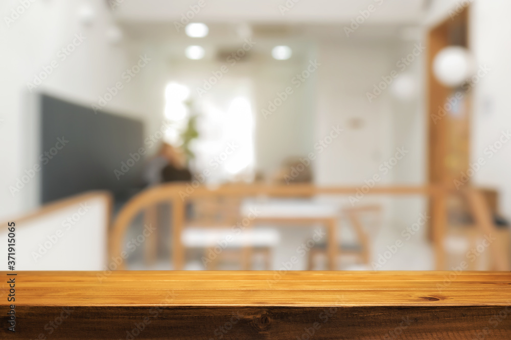 coffee shop blurred background with empty wooden desk montage. coffee shop blurred background with empty wooden desk montage.
