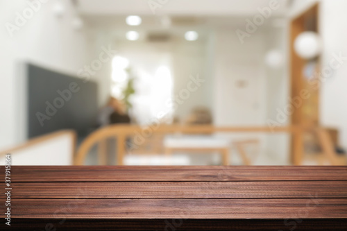 coffee shop blurred background with empty wooden desk montage.