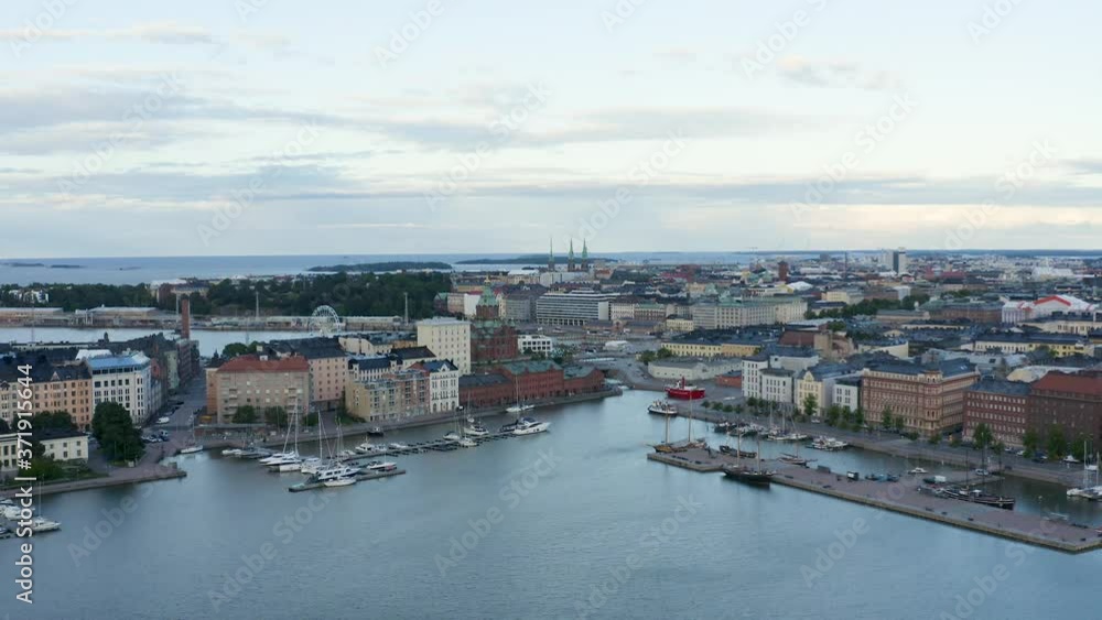 Slow aerial pan of boats along the waterfront with a ferris wheel in view at dusk, Finland. Slow aerial pan of boats along the waterfront with a ferris wheel in view at dusk, Finland.