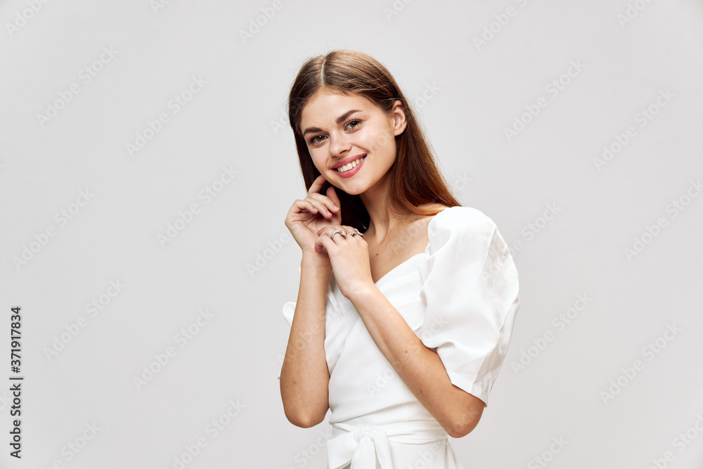 Smiling woman with long hair white dress hands near face Smiling woman with long hair white dress hands near face