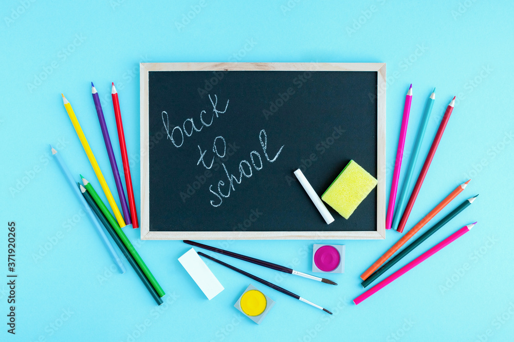 Graphite school board with the inscription Back to school and a number of colored pencils and school supplies. Start of training after quarantine. Copy space Graphite school board with the inscription Back to school and a number of colored pencils and school supplies. Start of training after quarantine. Copy space