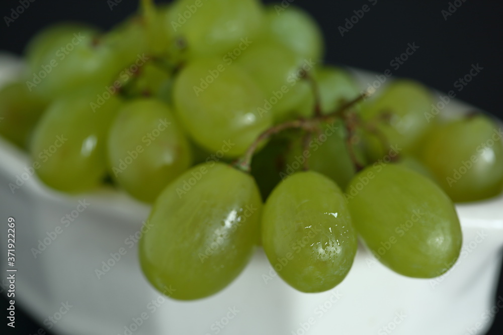 Fresh juicy green grapes on in a bowl close up on black background
Fresh juicy green grapes on in a bowl close up on black background