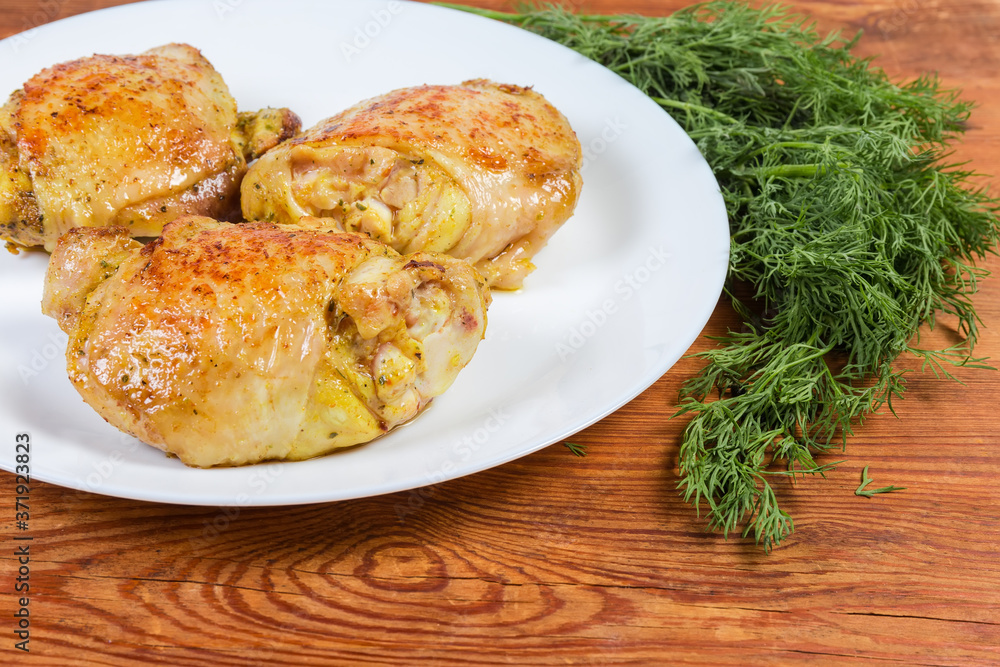 Fried chicken thighs on dish and dill on rustic table Fried chicken thighs on dish and dill on rustic table