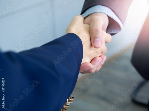 Businessman and businesswoman are shaking hands.