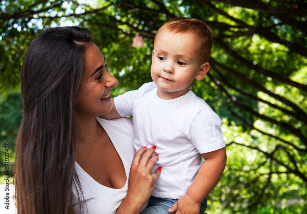 young pretty brunette mother with little cute boy walking in park happy smiling, lifestyle people concept young pretty brunette mother with little cute boy walking in park happy smiling, lifestyle people concept