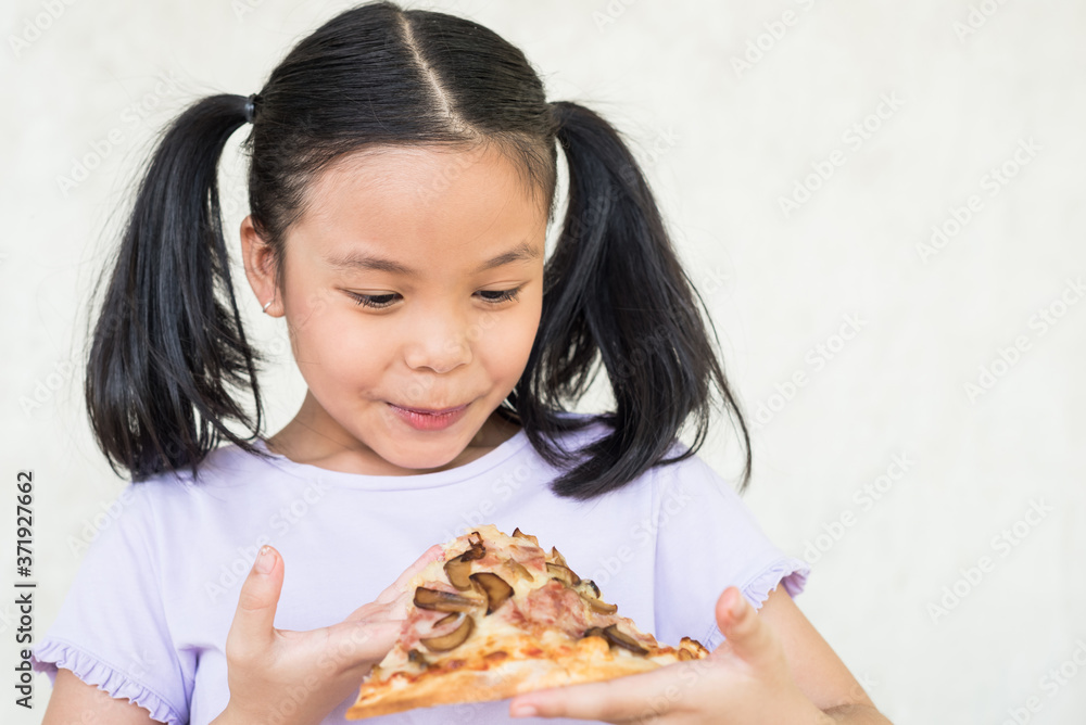 Mmm, so delicious! dark haired little asia girl eats slice of Italian pizza, keeps eyes closed from pleasure, enjoys nice taste, has good appetite, dressed in casual purple shirt, eating concept. Mmm, so delicious! dark haired little asia girl eats slice of Italian pizza, keeps eyes closed from pleasure, enjoys nice taste, has good appetite, dressed in casual purple shirt, eating concept.
