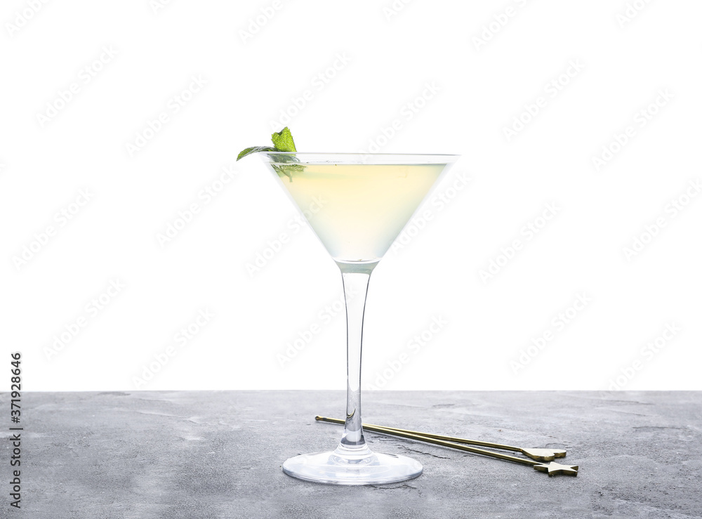 Glass of fresh martini on table against white background