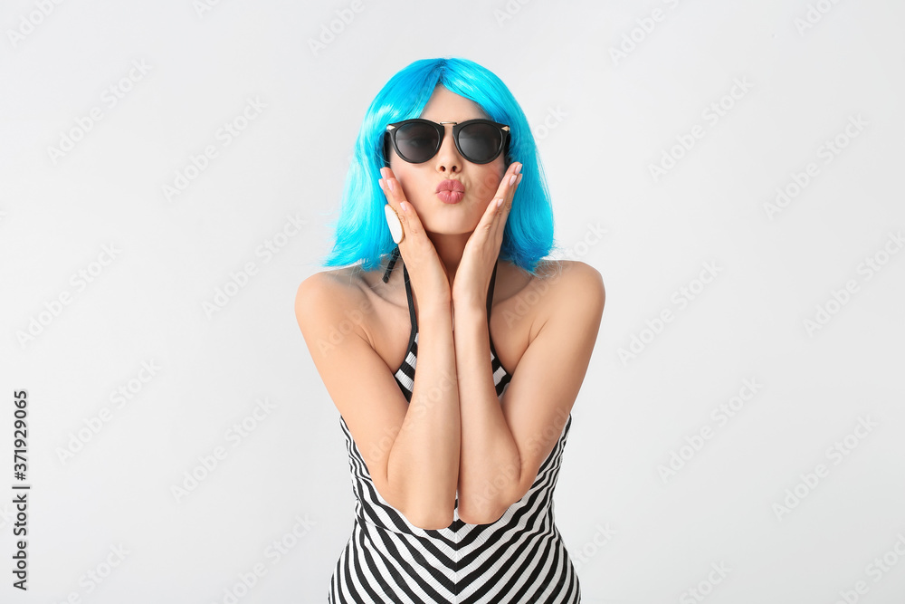 Beautiful young woman in wig on light background Beautiful young woman in wig on light background