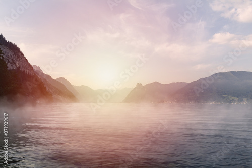 Sunset on Traunsee lake with alps mountain and misty fog. Summer Austria landscape photo