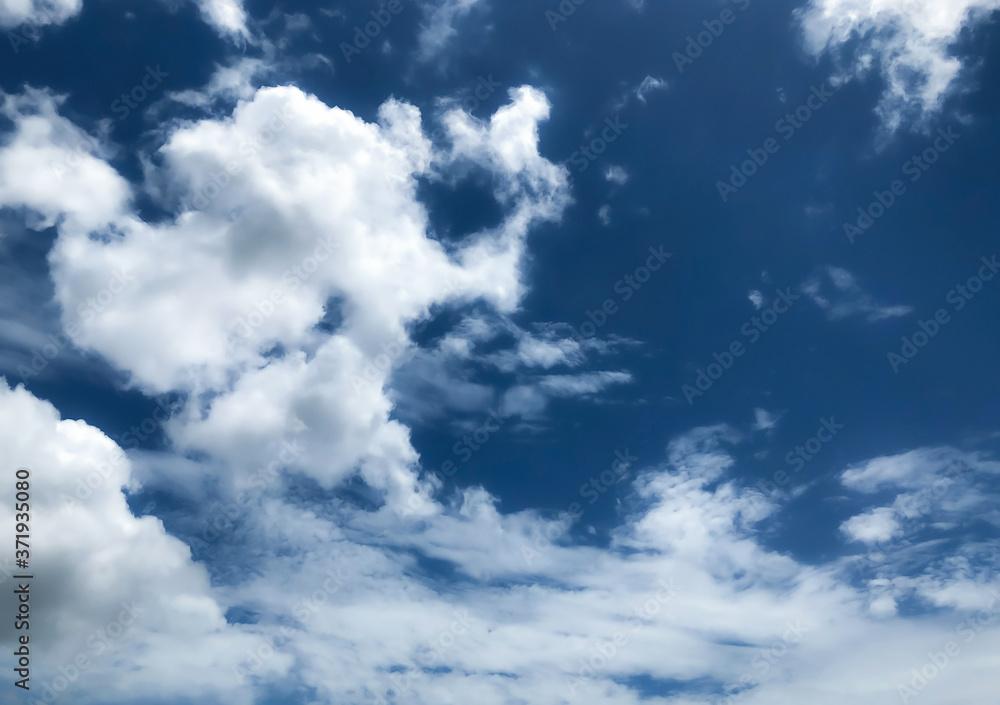 Obraz premium The blue sky with soft clouds for the background, view of a comfortable blue sky, relaxing and fresh, blue sky with dreamy soft clouds, the concept of creating a clear sky and clouds for Bright life.