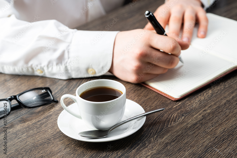 Man making notes with pen in notebook Man making notes with pen in notebook
