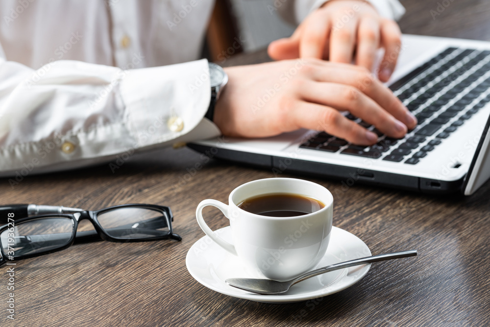 Businessman sitting at desk and using laptop Businessman sitting at desk and using laptop