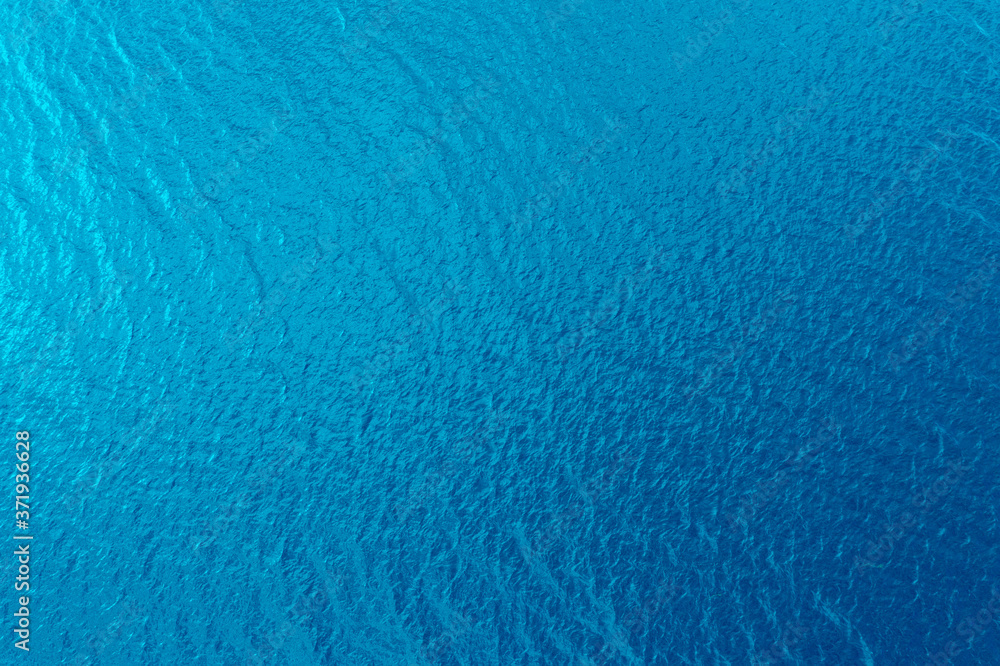 Aerial view of a crystal clear sea water texture. View from above Natural blue background. Blue water reflection. Blue ocean wave. Summer sea. Drone. Top view - obrazy, fototapety, plakaty 