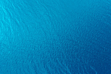 Aerial view of a crystal clear sea water texture. View from above Natural blue background. Blue water reflection. Blue ocean wave. Summer sea. Drone. Top view