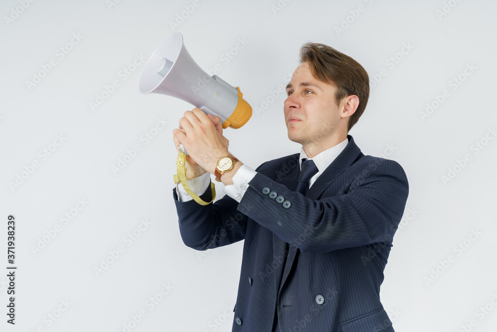 A businessman speaks into a loudspeaker. White background. A businessman speaks into a loudspeaker. White background.
