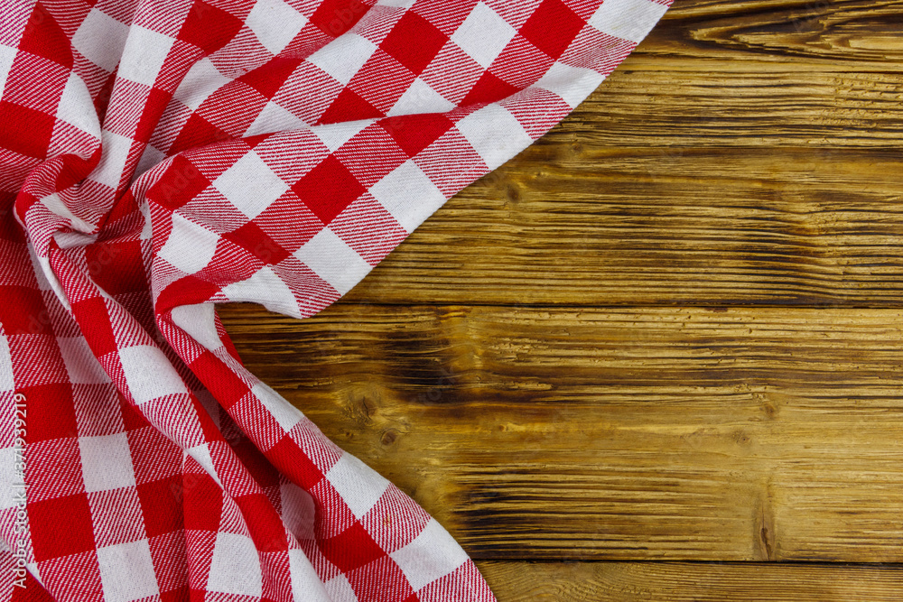 Red folded checkered napkin on rustic wooden kitchen table. Top view, copy space Red folded checkered napkin on rustic wooden kitchen table. Top view, copy space